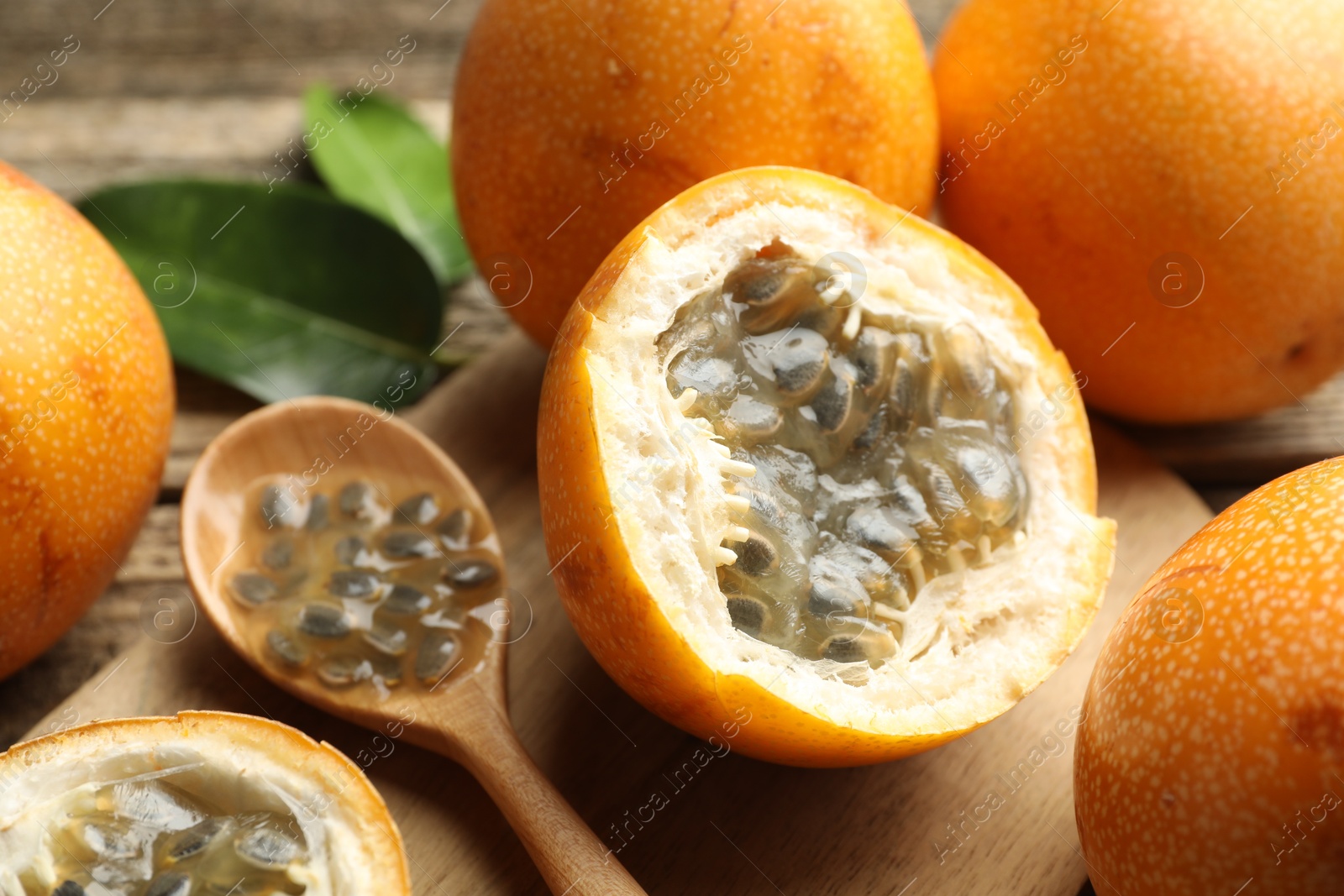 Ripe passion fruits, seeds and green leaves on table, closeup Photo of Ripe passion fruits, seeds and green leaves on table, closeup