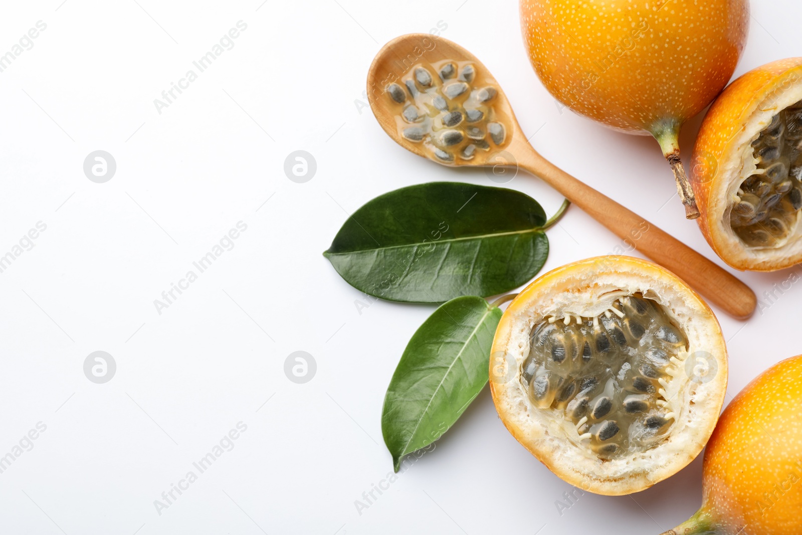 Ripe passion fruits, seeds and leaves on white background, flat lay. Space for text Photo of Ripe passion fruits, seeds and leaves on white background, flat lay. Space for text