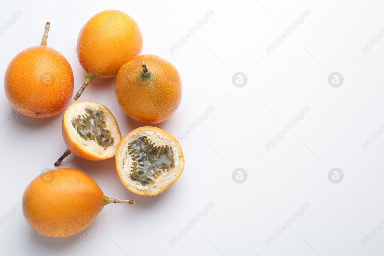 Ripe passion fruits on white background, flat lay. Space for text Photo of Ripe passion fruits on white background, flat lay. Space for text