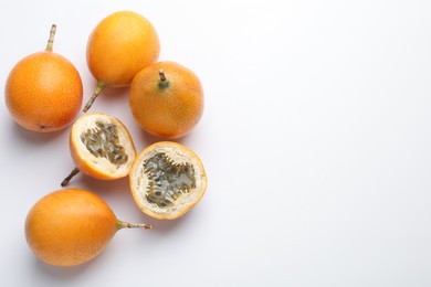 Photo of Ripe passion fruits on white background, flat lay. Space for text