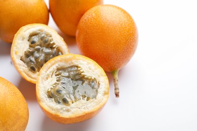 Photo of Ripe passion fruits on white background, closeup. Space for text