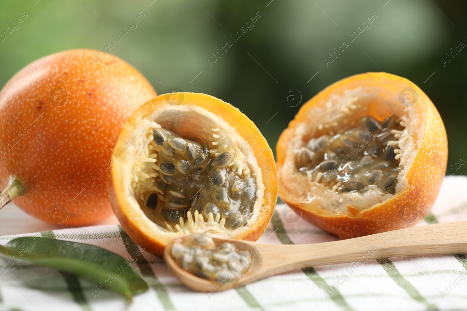 Ripe passion fruits, green leaf and seeds on table outdoors, closeup Photo of Ripe passion fruits, green leaf and seeds on table outdoors, closeup