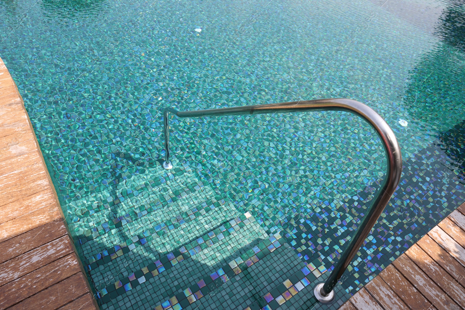 Outdoor swimming pool with steps and rail at resort Photo of Outdoor swimming pool with steps and rail at resort