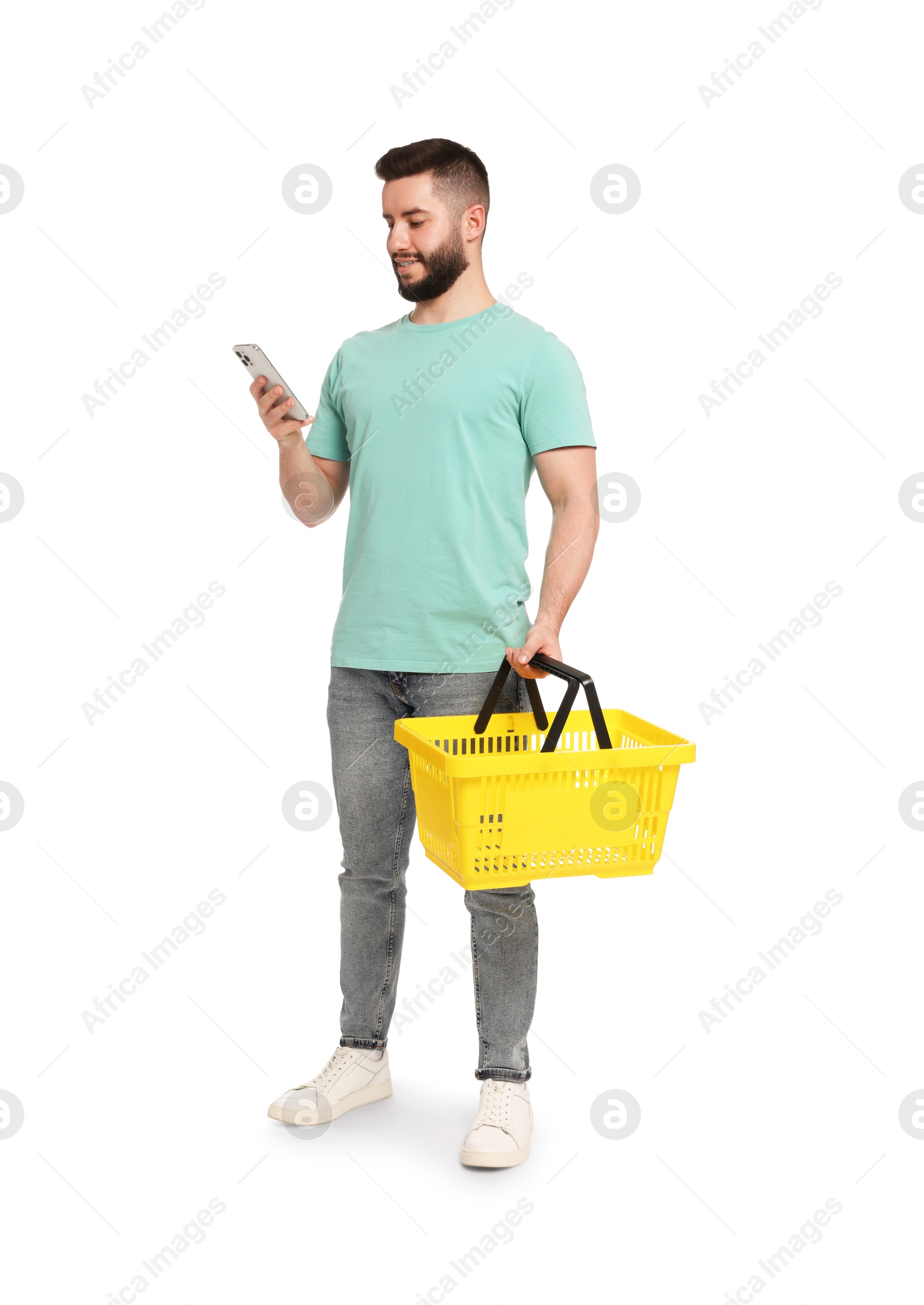 Man with empty shopping basket using smartphone on white background Photo of Man with empty shopping basket using smartphone on white background