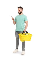 Photo of Man with empty shopping basket using smartphone on white background