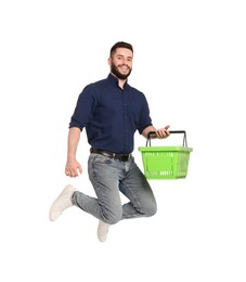 Photo of Man with empty shopping basket jumping on white background