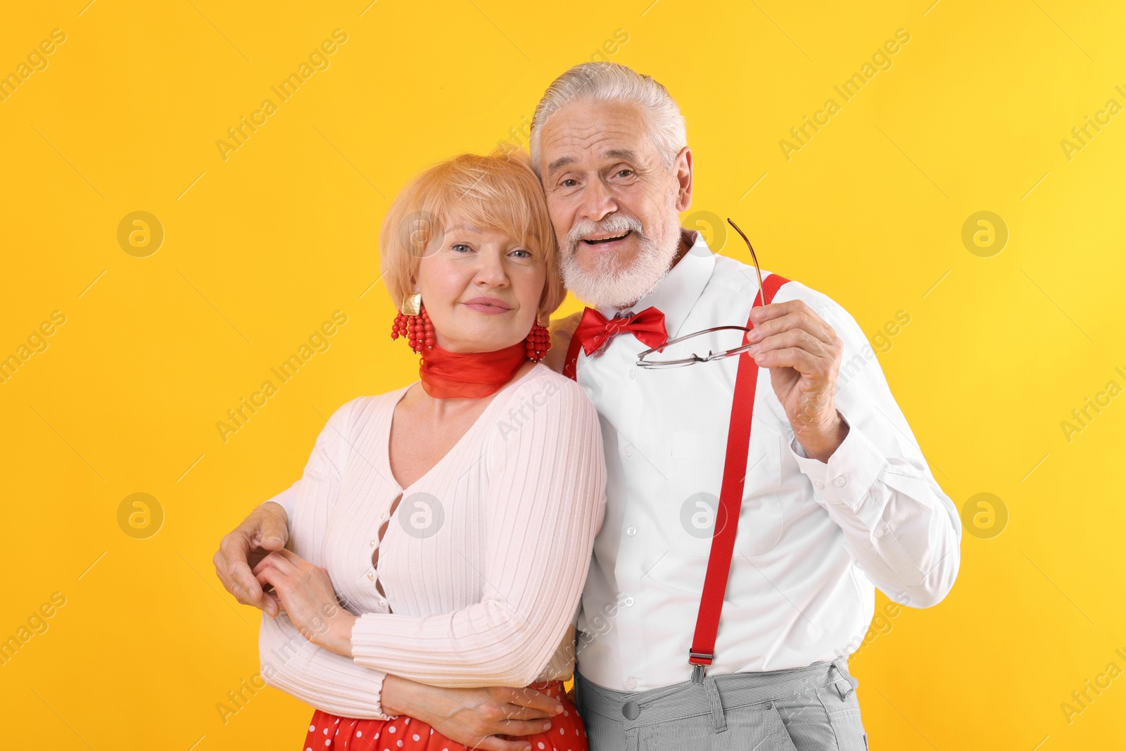 Lovely senior couple together on yellow background Photo of Lovely senior couple together on yellow background