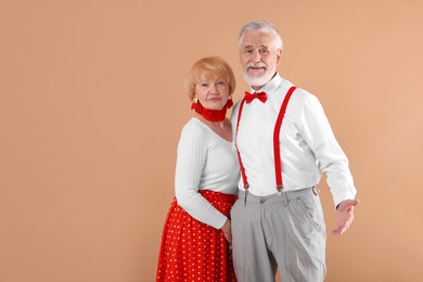 Photo of Lovely senior couple together on light brown background, space for text