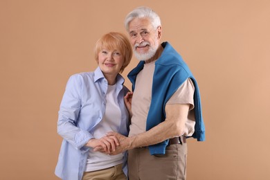 Photo of Lovely senior couple together on light brown background