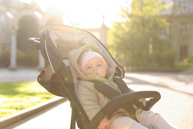 Photo of Cute little baby in stroller at park on sunny day