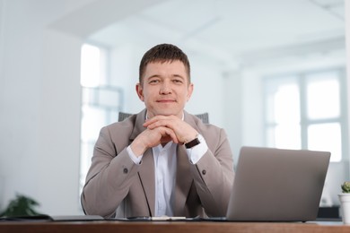 Photo of Portrait of handsome man at desk in office