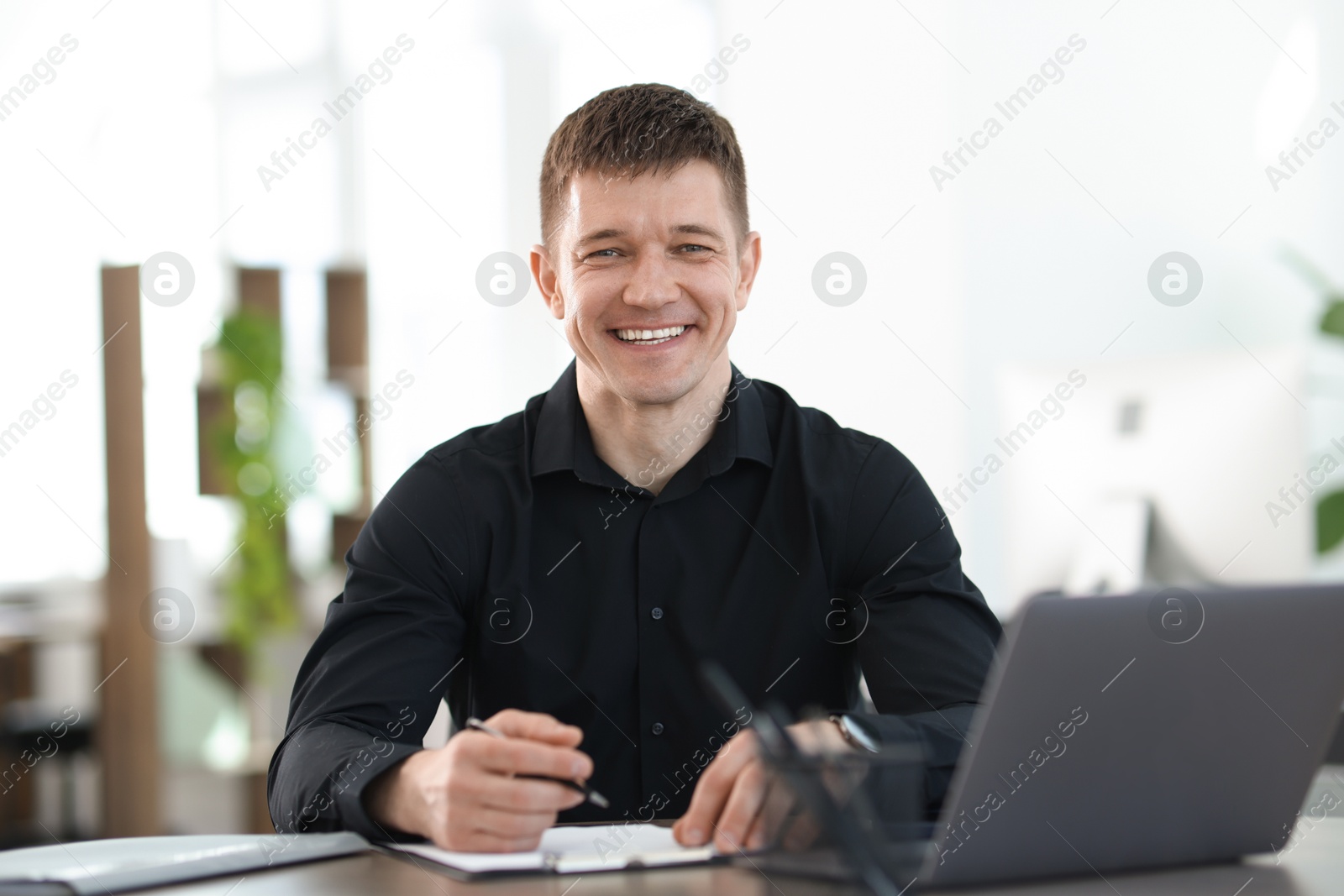 Photo of Handsome man working at desk in office