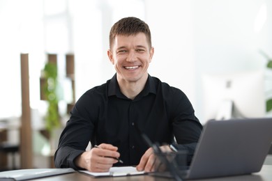 Photo of Handsome man working at desk in office