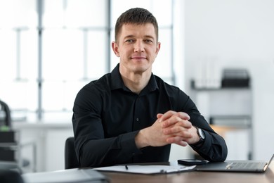 Photo of Portrait of handsome man at desk in office