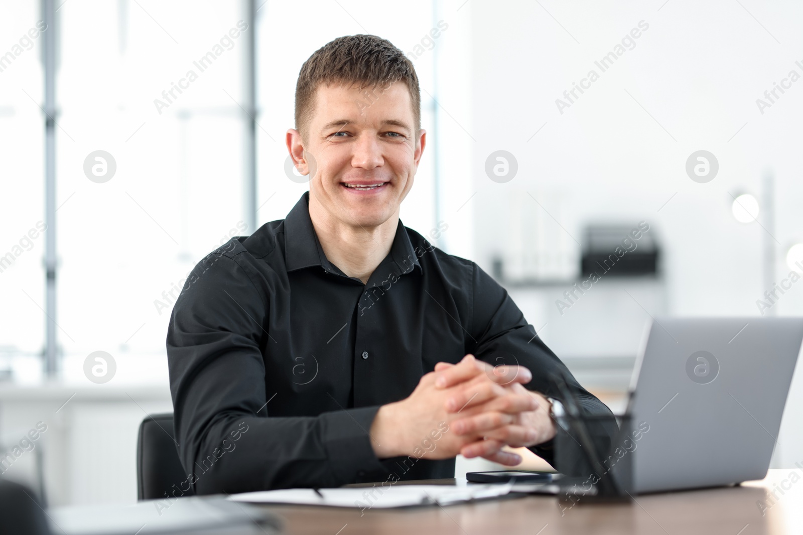 Portrait of handsome man at desk in office Photo of Portrait of handsome man at desk in office