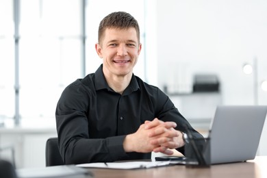 Photo of Portrait of handsome man at desk in office