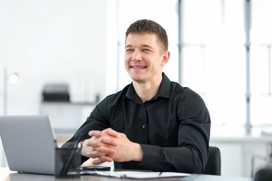 Photo of Portrait of handsome man at desk in office