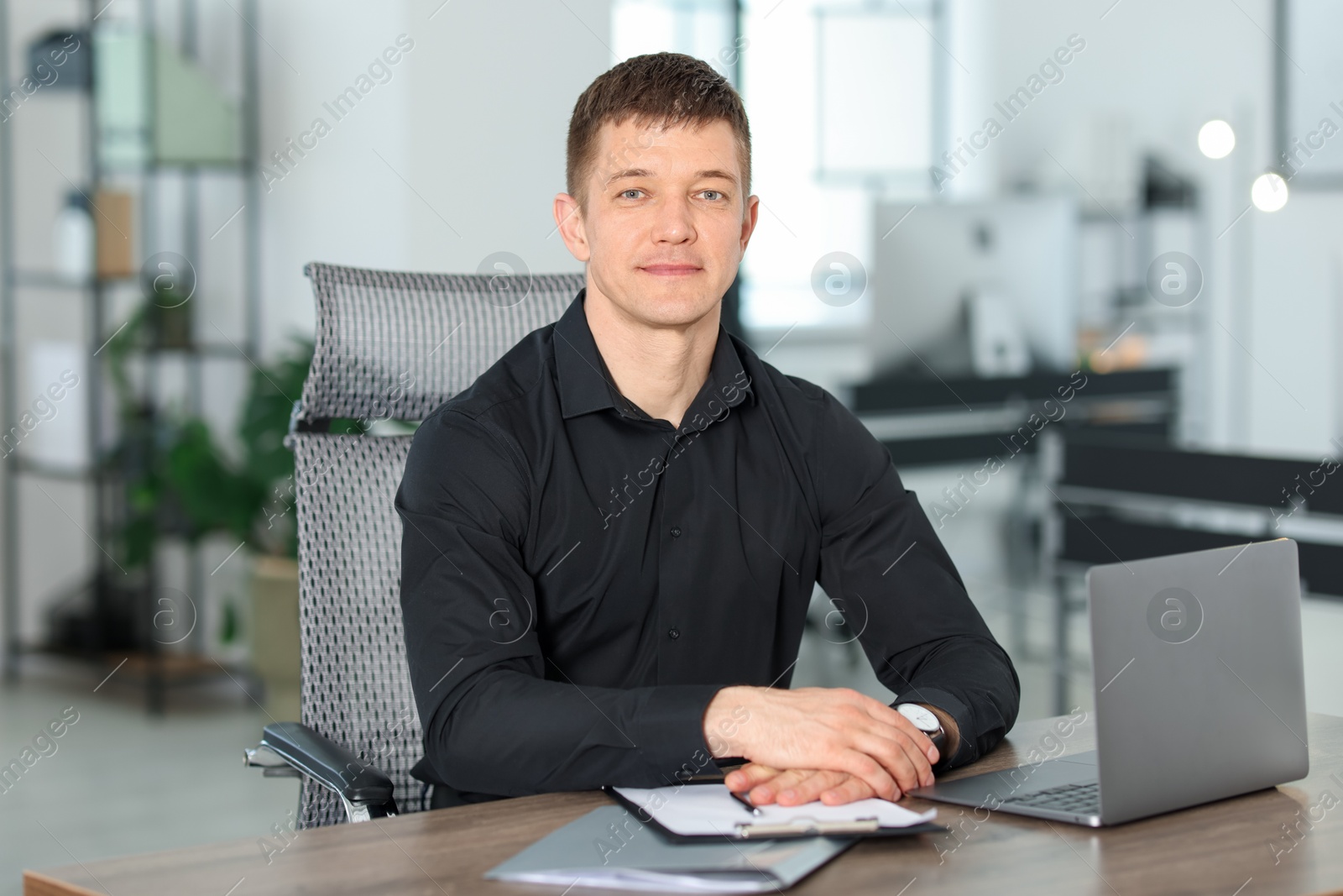 Portrait of handsome man at desk in office Photo of Portrait of handsome man at desk in office