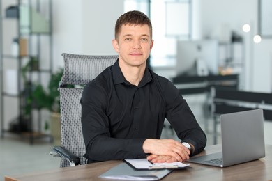 Photo of Portrait of handsome man at desk in office
