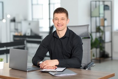 Photo of Portrait of handsome man at desk in office