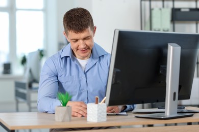 Photo of Handsome man working at desk in office