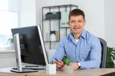 Photo of Handsome man working at desk in office