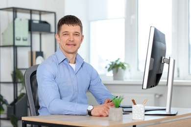 Photo of Handsome man working at desk in office