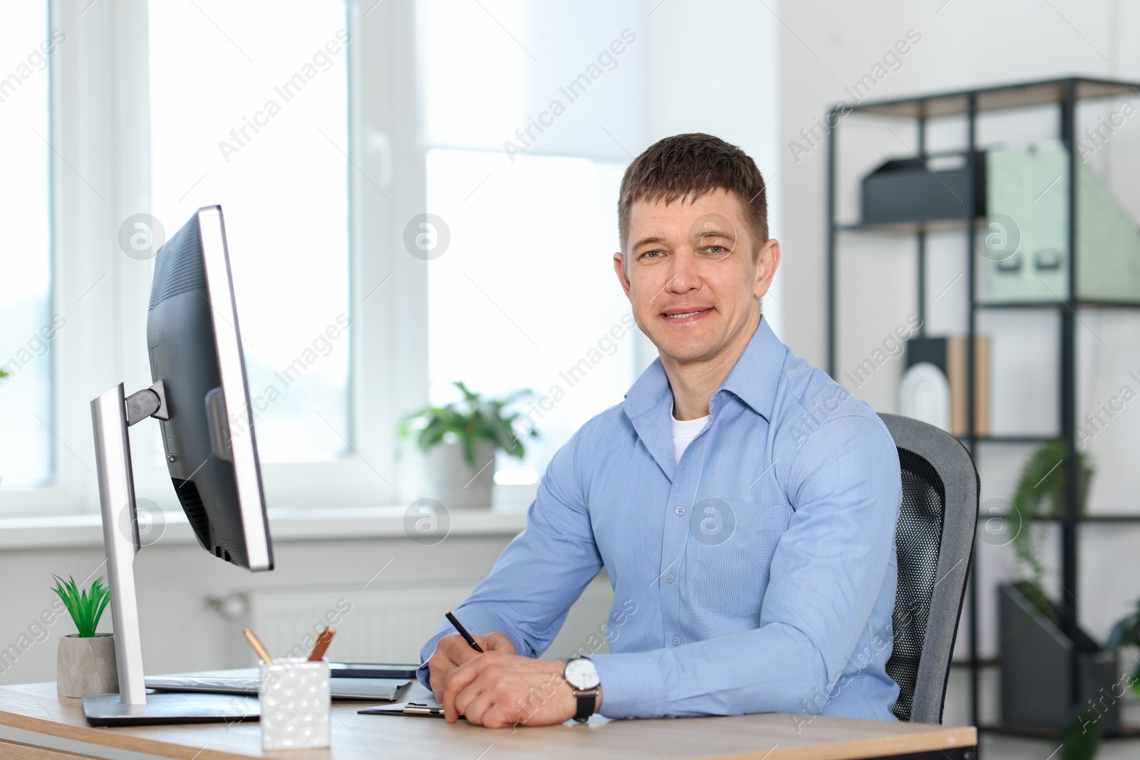 Handsome man working at desk in office Photo of Handsome man working at desk in office