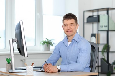 Photo of Handsome man working at desk in office