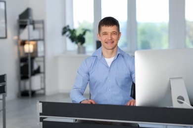Photo of Portrait of handsome man at desk in office