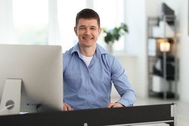 Photo of Portrait of handsome man at desk in office