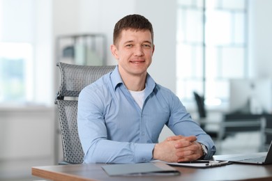 Photo of Portrait of handsome man at desk in office