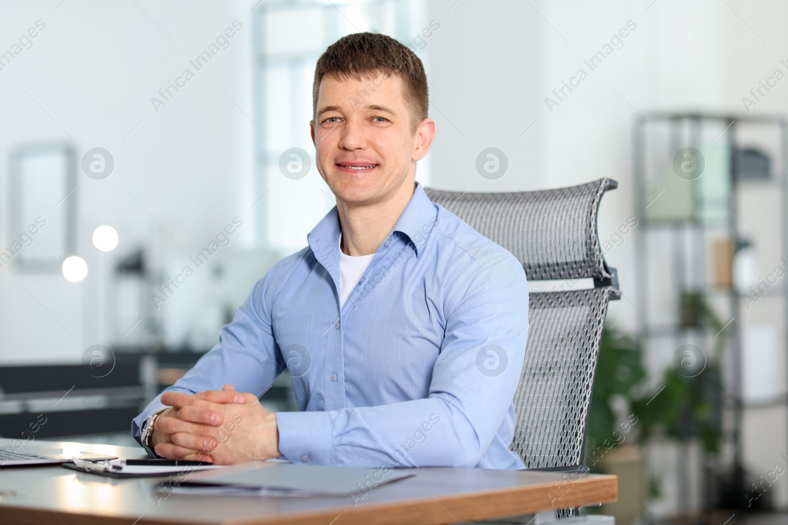Portrait of handsome man at desk in office Photo of Portrait of handsome man at desk in office