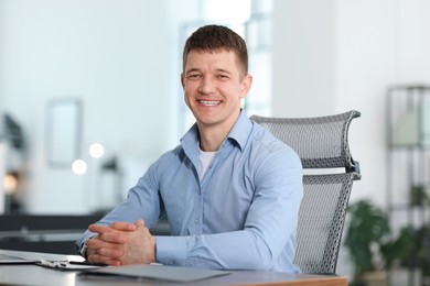 Photo of Portrait of handsome man at desk in office