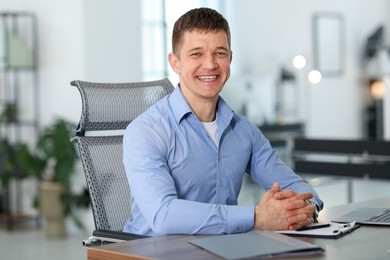 Photo of Portrait of handsome man at desk in office