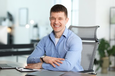 Photo of Portrait of handsome man at desk in office