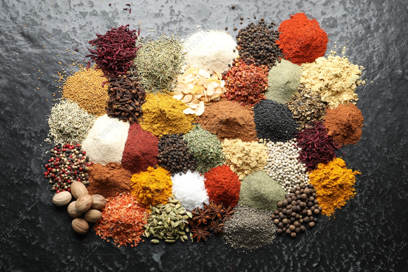 Many different spices on dark table, flat lay Photo of Many different spices on dark table, flat lay