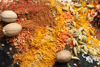 Photo of Many different spices on dark table, above view