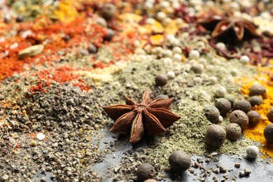 Photo of Many different spices on dark table, closeup