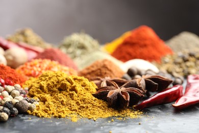 Photo of Many different spices on dark table, closeup