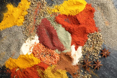 Photo of Many different spices on dark table, flat lay