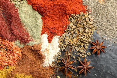 Photo of Many different spices on dark table, flat lay