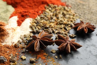 Photo of Many different spices on dark table, closeup