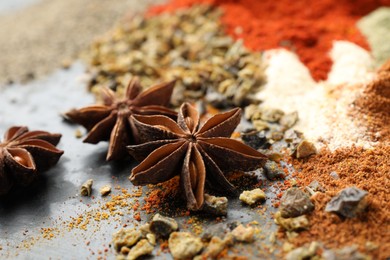 Photo of Many different spices on dark table, closeup