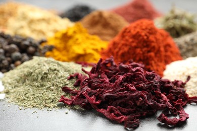 Photo of Many different spices on dark table, closeup