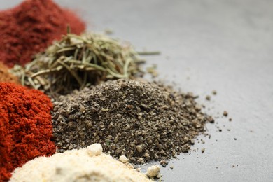 Photo of Many different spices on grey table, closeup. Space for text