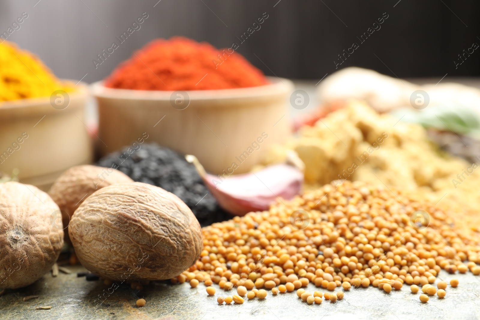 Many different spices on grey table, closeup Photo of Many different spices on grey table, closeup