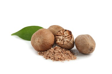 Photo of Whole, cut nutmegs, powder and leaf isolated on white