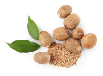 Photo of Whole nutmegs, powder and leaves isolated on white, top view