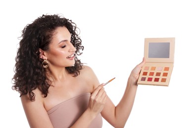 Photo of Smiling woman with eyeshadow palette and brush on white background
